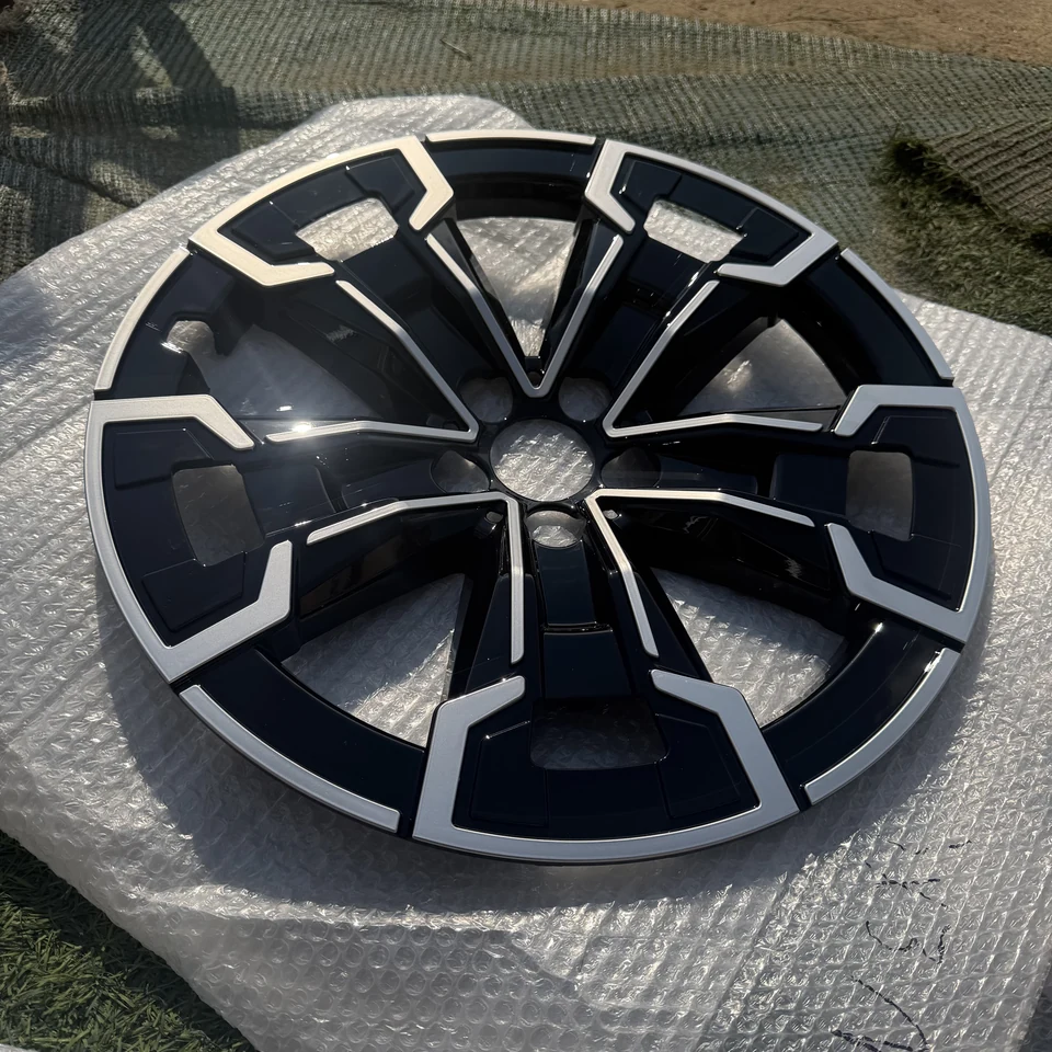 Actual front photograph of a black and silver BMW iX3 ABS wheel trim cover